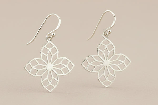 Silver floral earrings on a gray background