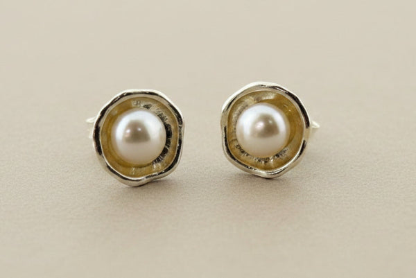 Pair of pearl stud earrings on a gray background