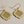 Load image into Gallery viewer, Gold earrings with intricate design on a beige background
