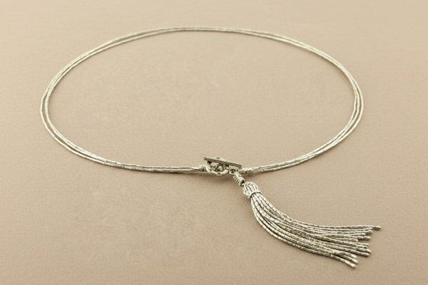 Necklace with tassel on a gray background