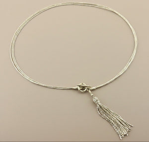Necklace with a tassel on a gray background
