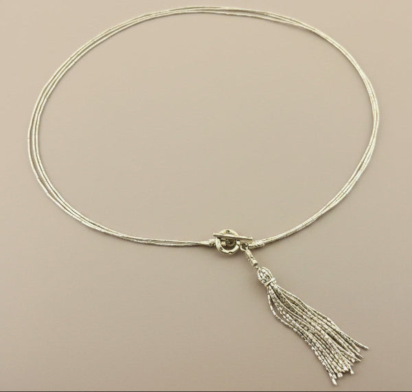 Necklace with a tassel on a gray background