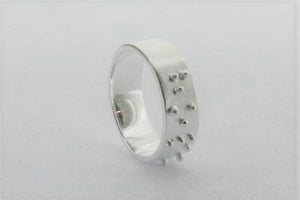 silver ring with braille detail spelling hope