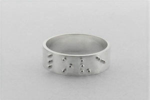 silver ring with braille detail spelling love